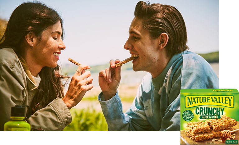 woman and man enjoying Nature Valley Crunchy bars outdoors